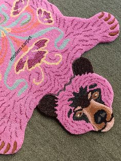 a pink bear rug on the ground with it's paw sticking out from its mouth