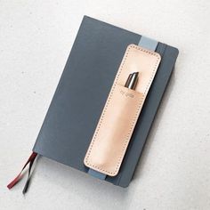 a notebook with a pen in it sitting on top of a table