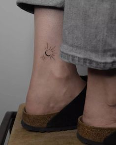 a woman's foot with a small sun tattoo on her left ankle, and an open