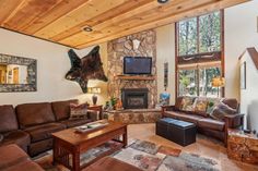 a living room filled with furniture and a stone fireplace