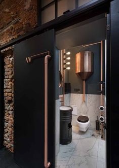 a bathroom with black walls and copper fixtures