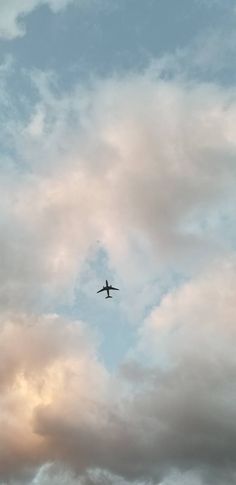 an airplane is flying through the cloudy sky