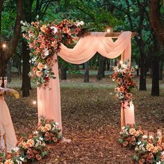 an outdoor wedding set up in the woods with flowers and candles on the altars