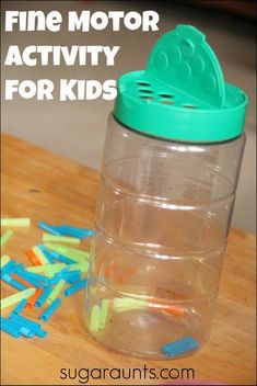 a plastic container filled with lots of colorful magnets on top of a wooden table