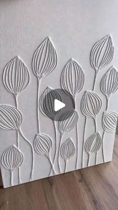 an image of a paper art work with flowers on the side and a video play button in the middle