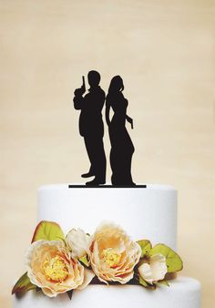 a wedding cake topper with two silhouettes of the bride and groom on it