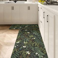 a kitchen with white cabinets and an area rug in the middle that has flowers on it