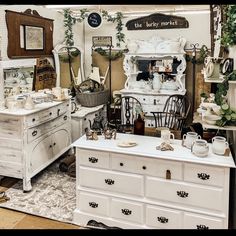 a room filled with white furniture and lots of plants on top of it's shelves