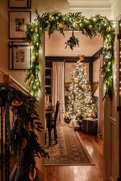 a decorated christmas tree sitting in the middle of a living room next to a doorway