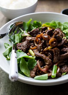 a white bowl filled with meat and vegetables