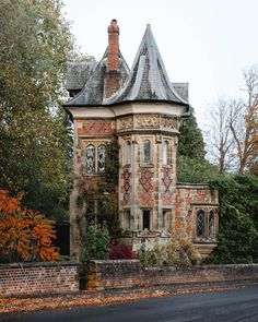 an old brick house with a tower and ivy growing on it