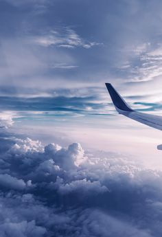 an airplane wing flying above the clouds