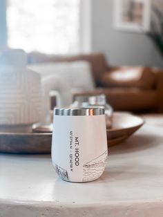 a white cup sitting on top of a table