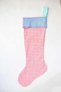 a pink and white checkered stocking with a blue ribbon hanging from it's side