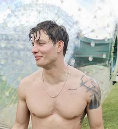 a shirtless man standing in front of a large bubble