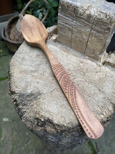 a wooden spoon sitting on top of a rock next to a pile of wood blocks