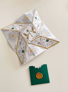 an origami piece with a gold cross on it