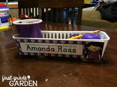 there is a plastic container with writing on it that says amanda ross and has two pencils in it