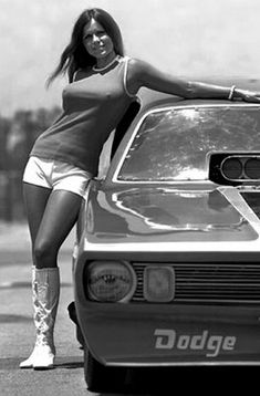 a woman leaning on the hood of a car