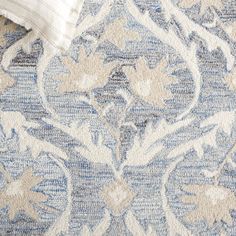 a blue and white rug with an intricate design on the bottom corner, in close up