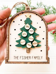 a hand holding a christmas ornament that says dad, mom, father's day