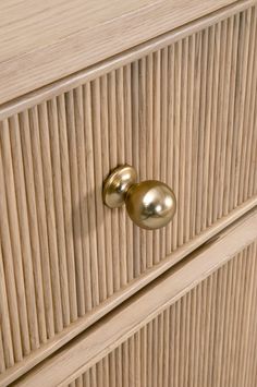 a wooden dresser with two brass knobs on it