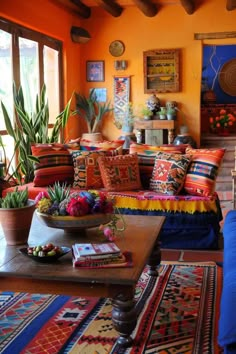 a living room filled with lots of furniture and colorful pillows on top of it's couch