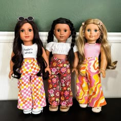 three dolls are standing next to each other