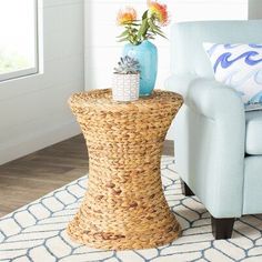 a living room with a blue chair and vase on top of a wicker table