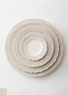 four white plates stacked on top of each other in the shape of a spiral pattern