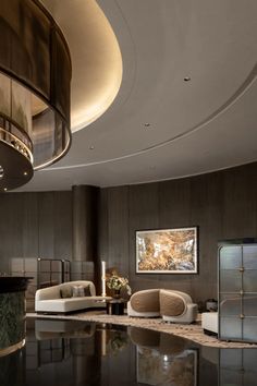 a living room filled with furniture next to a round table and chandelier hanging from the ceiling