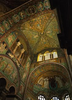 the interior of an ornately decorated building with stained glass windows and paintings on the ceiling