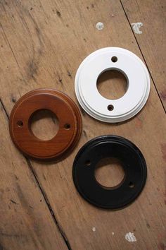 three different types of wood and plastic parts on a wooden surface with holes in the middle