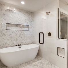 a white bath tub sitting inside of a bathroom next to a walk - in shower