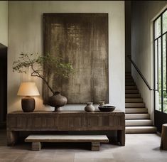 a living room with two vases and a painting on the wall above it's console table