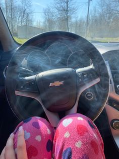 a person sitting in a car with their feet on the steering wheel