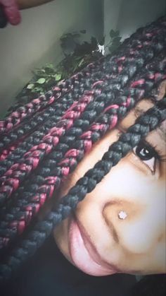 a close up of a person with braids on their head and one eye open