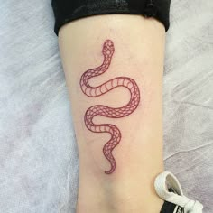 a woman's foot with a red snake tattoo on it