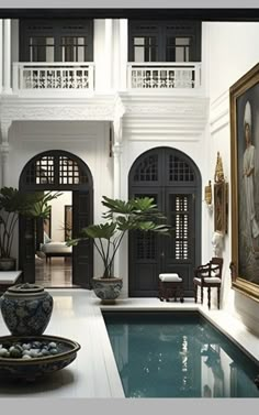 an indoor swimming pool in the middle of a room with two paintings on the wall