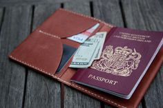 a passport and some money sitting on top of a wooden table