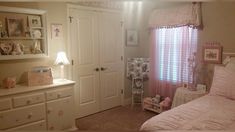 a bedroom with pink curtains and white furniture