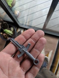 a hand holding a small metal object in it's palm