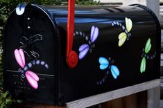 a black mailbox with colorful dragon designs painted on it