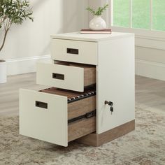 three drawers are stacked on top of each other in front of a window with a potted plant