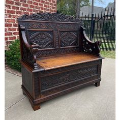 an old wooden bench sitting in front of a brick building with ironwork on it