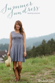 a woman in a dress and cowboy boots is walking through the grass with her hat