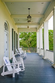 the porch is lined with white lawn chairs