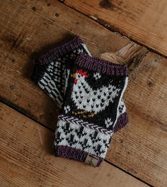 two knitted mittens sitting on top of a wooden floor