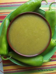 a bowl of soup with green peppers on the side