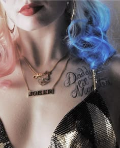 a woman with blue hair and tattoos on her chest